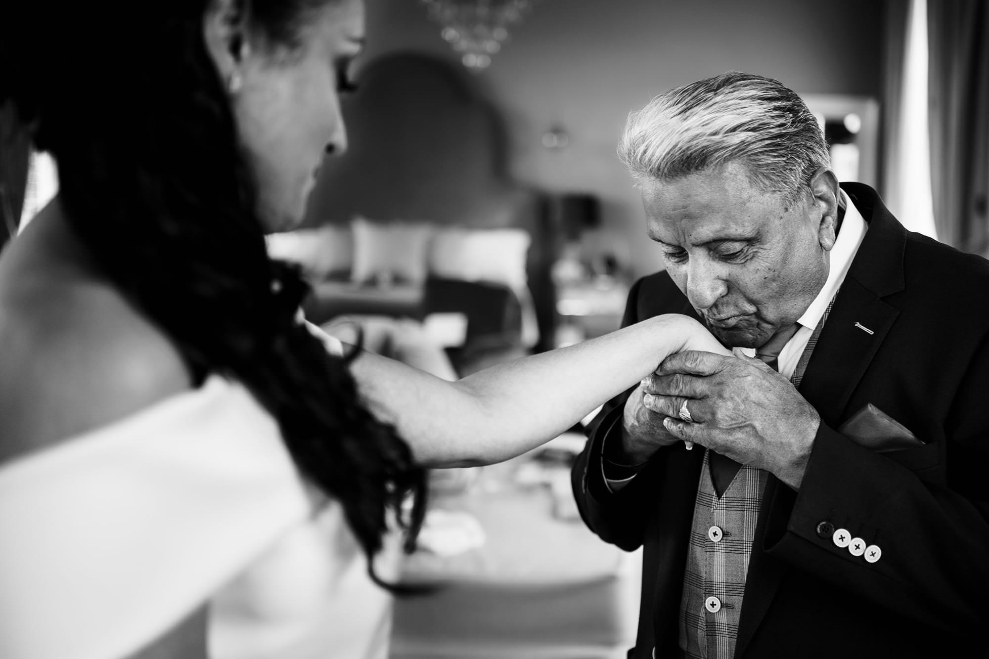 father of the bride captured candidly kissing his daughters hand