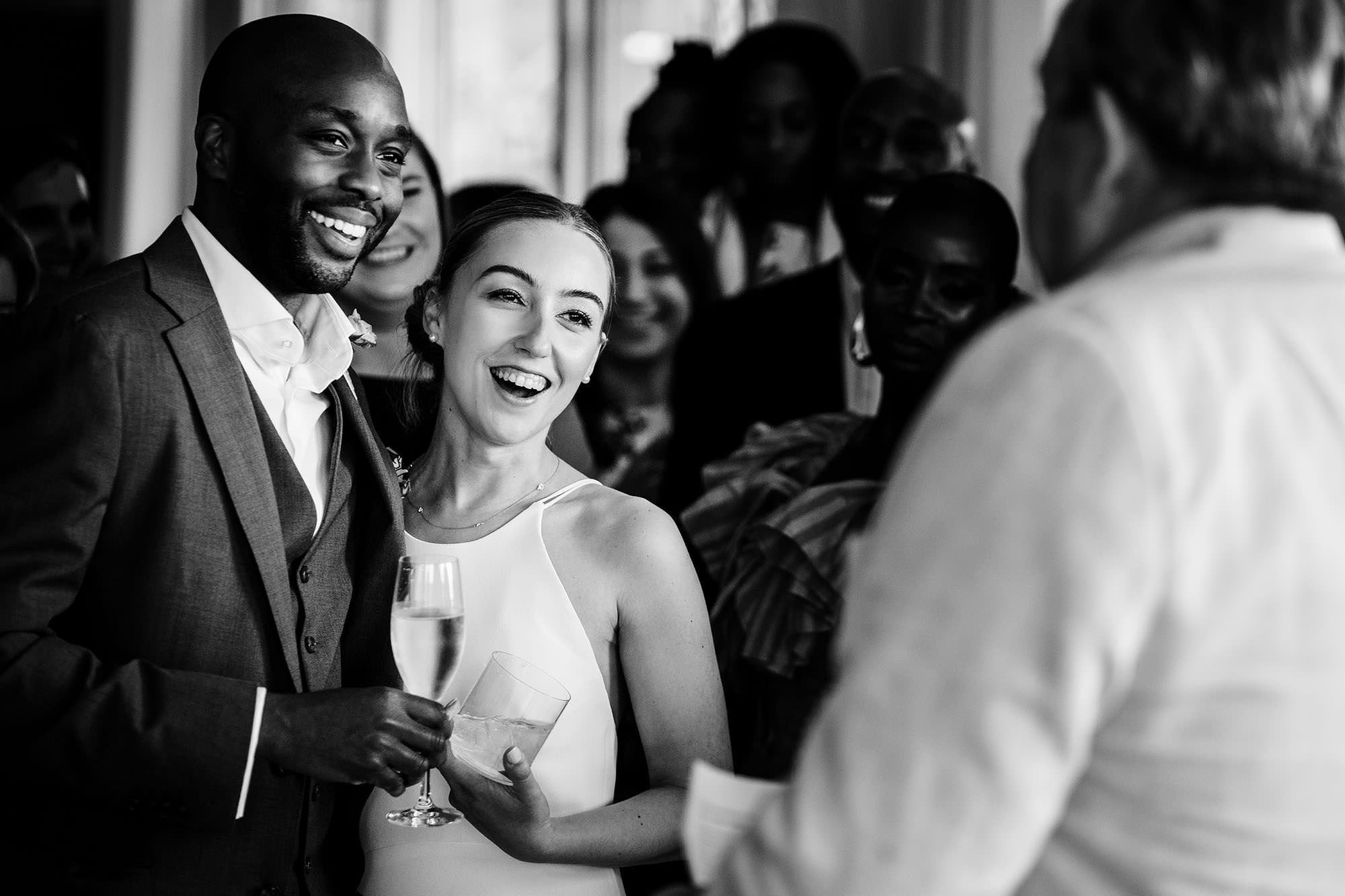bride and groom watching wedding spech in candid moment