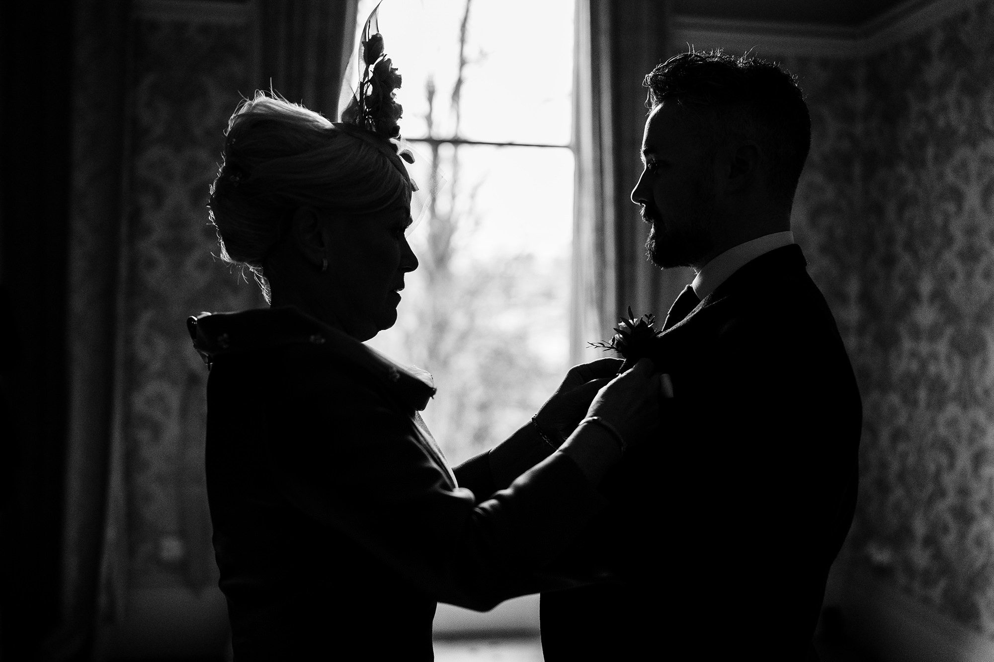 mother of the groom dresses her son at cotswolds wedding venue