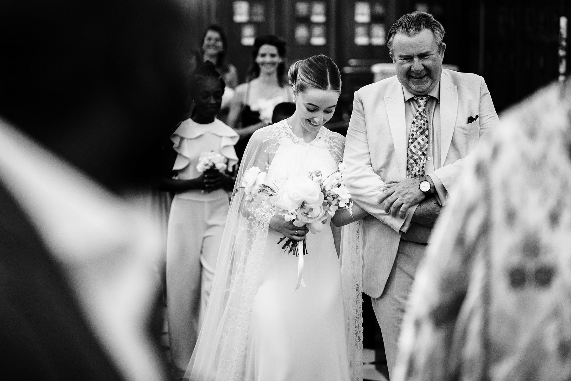bride walks down the aisle with her father for her wedding
