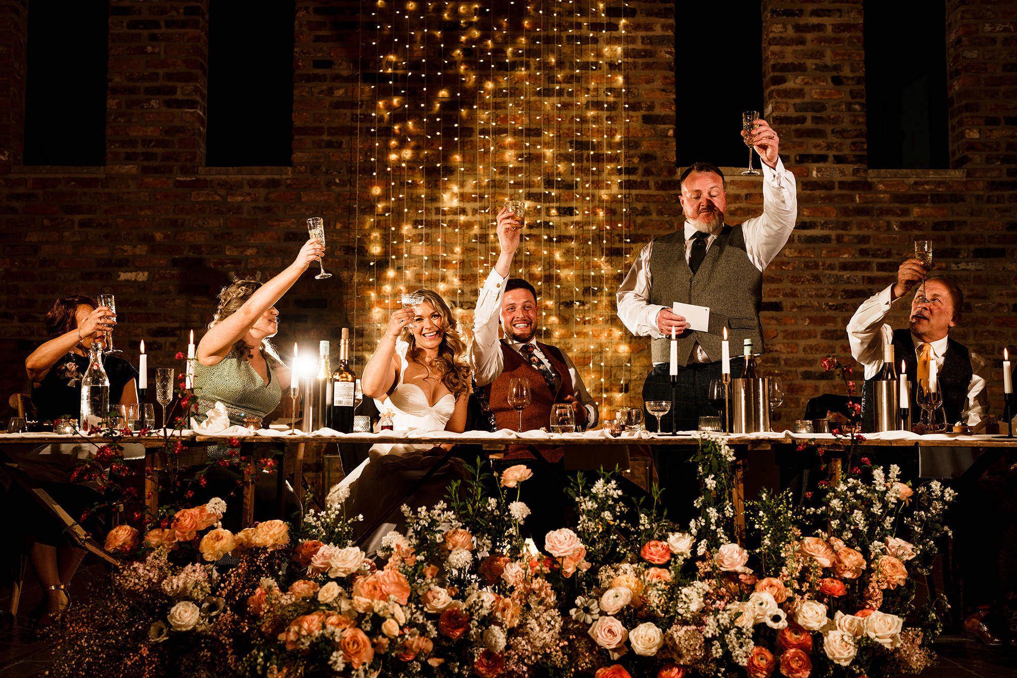 during a cotswolds wedding the speeches are taking place above beautiful flowers