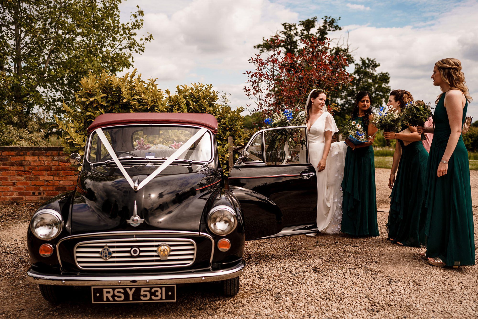 bride and her bridesmaids getting into the wedding car in Keswick