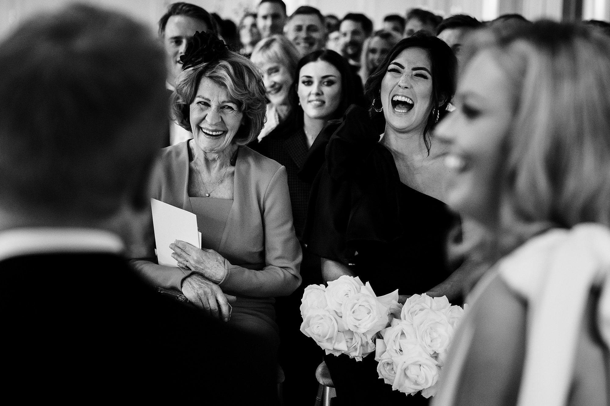 wedding guests laugh at lakes wedding ceremony