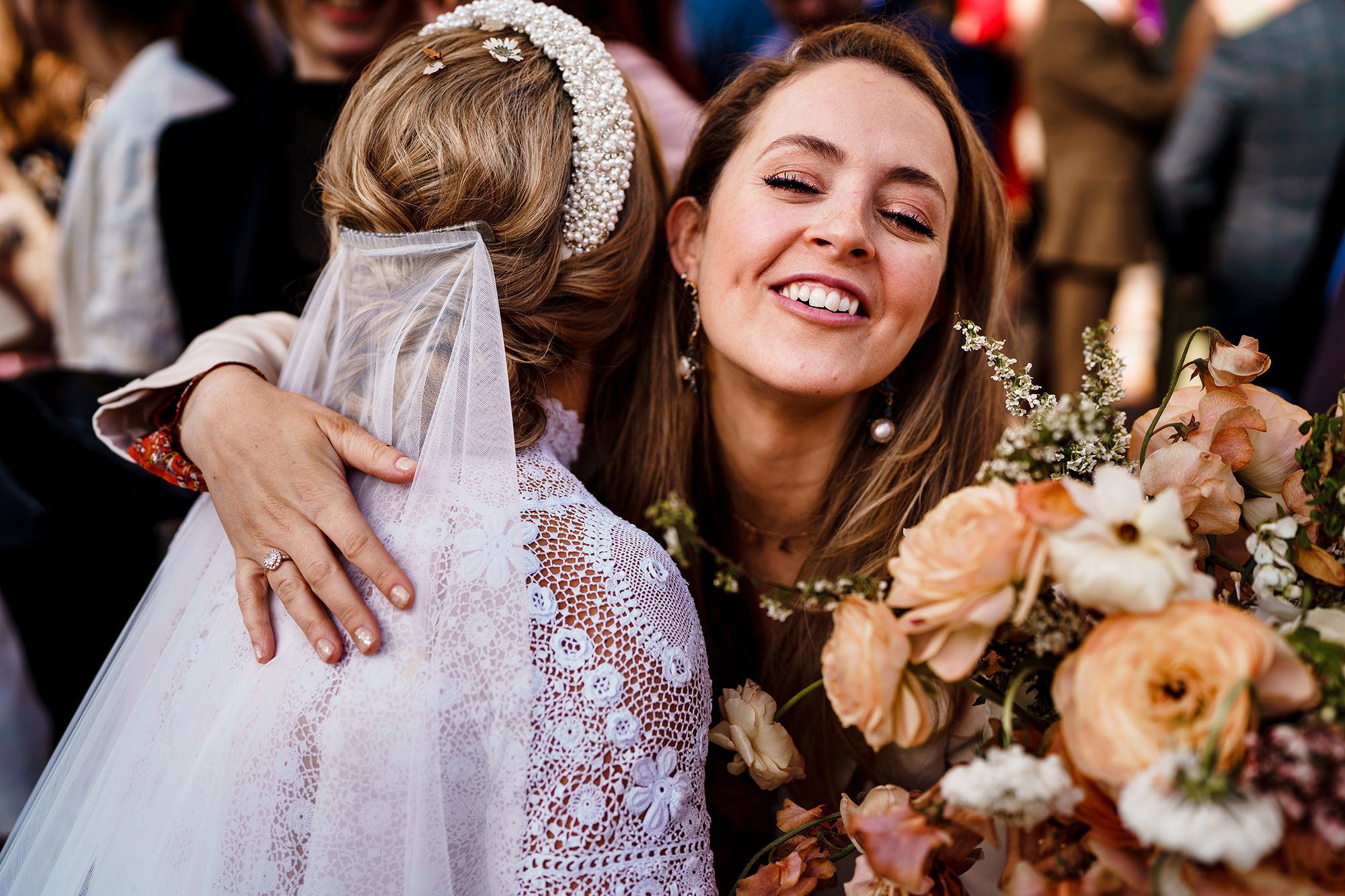 wedding guest hugs bride at outdoor wedding